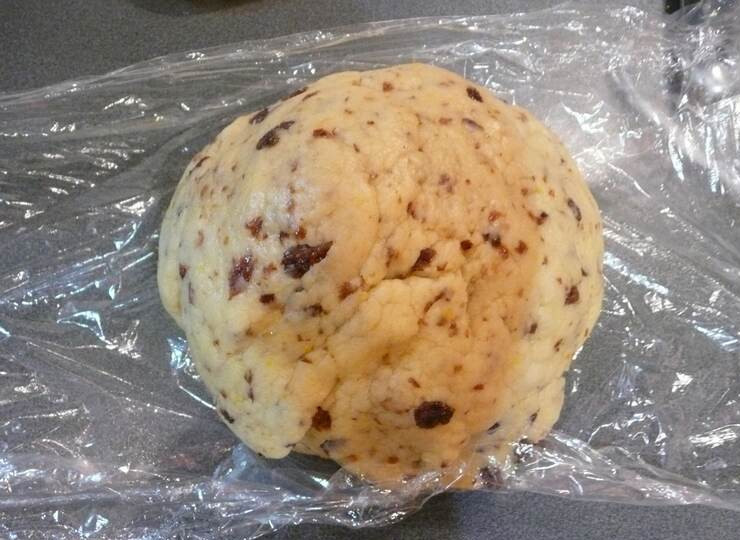 1. Этап. Печенье домашнее на сковороде: В тесто добавляем взбитое яйцо с молоком, месим. Затем добавляем изюм. Вымешиваем тесто руками, заворачиваем тесто в пленку и убираем не на долго в холодильник.