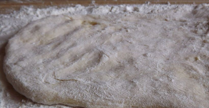 1. Этап. Тесто для пончиков: Присыпьте рабочую поверхность мукой и выложите на нее подошедшее тесто. Затем раскатайте тесто в пласт толщиной около одного сантиметра, посыпая его мукой, чтобы тесто не липло к рукам и скалке.