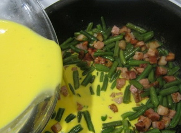 1. Этап. Омлет с крахмалом: Яйца взбейте с крахмалом и специями при помощи венчика. Добавьте сливки и вылейте смесь в сковороду.