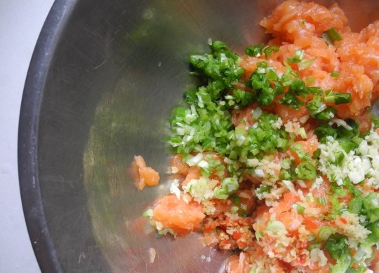 1. Этап. Пельмени с семгой: 1. Тесто для пельменей можете использовать свое любимое или покупное. Покупное удобно тем, что уже нарезано кусочками. Нам понадобится 30-40 кусочков покупного. Рыбу очистите от кожуры и мелко нарежьте. Переложите рыбу в глубокую емкость. К ней влейте соевый и рыбный соусы, мирин и сок лайма. Добавьте измельченные лук-шалот и чеснок. Также добавьте чили. Перемешайте.