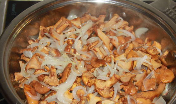 1. Этап. Лисички, запеченные в духовке: Разогреваем на сковороде растительное масло и обжариваем на нем измельченный лук. Затем добавляем грибочки и готовим вместе 10 минут.