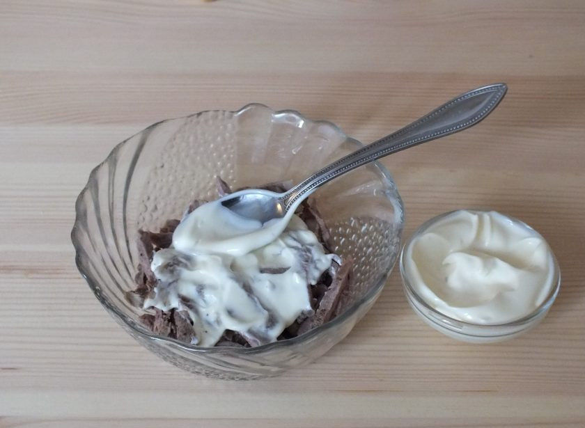 1. Этап. Салат Мужские слезы с говядиной: Возьмите небольшой салатник. Выложите дно нарезанной говядиной. Смажьте 1 ч.л. майонеза.