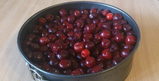 1. Этап. Пирог с маскарпоне и вишней: Вымойте ягоды. Если вы используете вишни с косточками, то удалите их. В форму с бисквитом засыпьте ягоды без косточек.