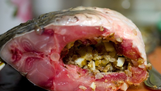 1. Этап. Рыба начиненная кашей: 4. Аккуратно поместите готовую начинку в брюшко. На сковороде разогрейте немного растительного масла, параллельно включите духовку.