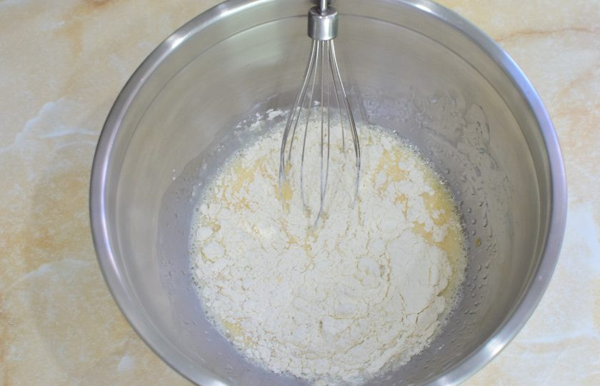 1. Этап. Блины с маскарпоне: Постепенно вмешивайте в тесто просеянную муку. Отрегулируйте густоту теста на свое усмотрение.