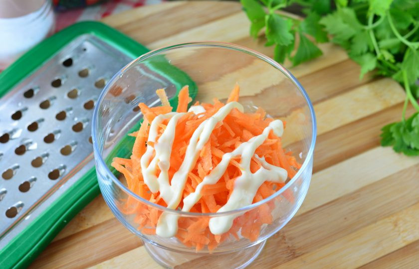 1. Этап. Салат Кудрявый с крабовыми палочками: Выложите салат слоями, первым слоем распределите морковку. Полейте майонезом.