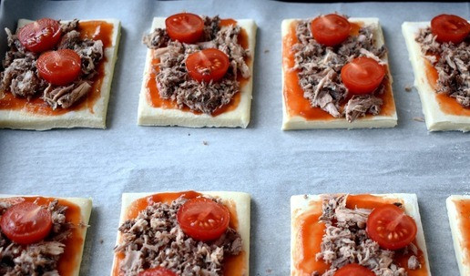 1. Этап. Слойки с консервированным тунцом: Помидоры черри разрезаем пополам и раскладываем на каждый кусочек.