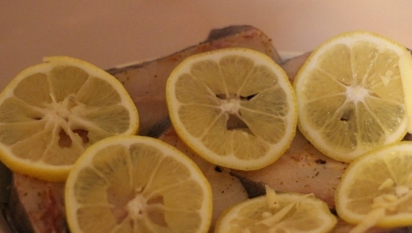 1. Этап. Рыба дори в духовке: Достаньте из холодильника рыбу и выложите в посуду, в которой вы будете запекать блюдо в духовке. Лимон вымойте и нарежьте кружочками. Выложите на каждый кусочек рыбы по кружочку лимона.