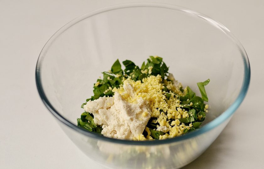 1. Этап. Слойки с щавелем: Добавьте риккоту и тертый сыр, перемешайте. Посолите и поперчите начинку по вкусу.