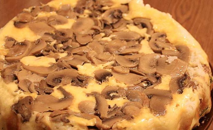 1. Этап. Слоеный пирог-перевертыш: Достаем готовый пирог из духовки и оставляем его на 15 минут, чтобы настоялся. Кладем сверху на пирог плоскую тарелку и переворачиваем его на 180 градусов. Бумагу для выпечки удаляем.