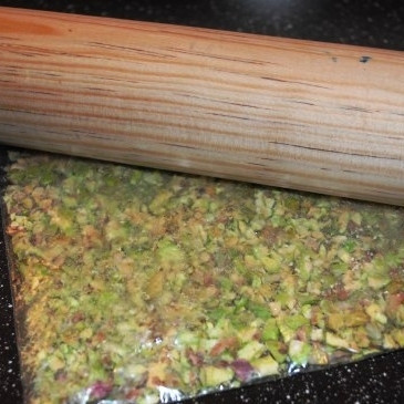 1. Этап. Сырные шарики с фисташками и виноградом: ...и скалкой хорошенько раскалываем наши фисташки. В крошку превращать не надо, однако кусочки фисташек должны получиться весьма маленькими.