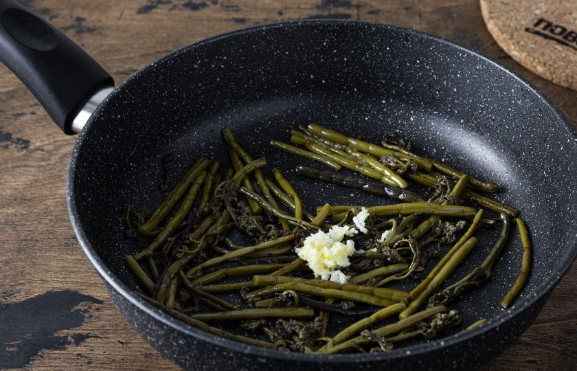 1. Этап. Жареная картошка с папоротником: Разогрейте сковороду с растительным маслом. Обжарьте папоротник 1-2 минуты. Затем добавьте измельченный чеснок. Слегка поперчите. Жарьте еще 1-2 минуты. Затем отложите в сторону.