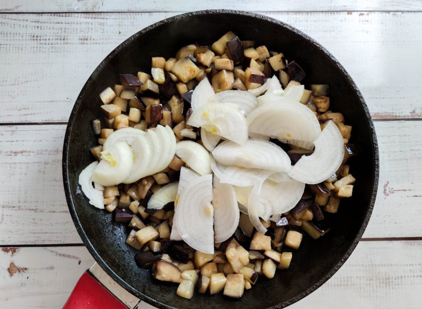 1. Этап. Салат из жареных баклажанов с майонезом: Лук очистите от шелухи, нарежьте полукольцами и добавьте его к баклажанам. Обжарьте все до готовности.