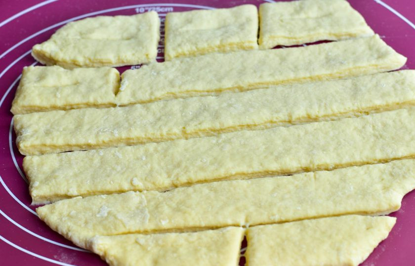 1. Этап. Хворост на кефире с водкой: Тесто раскатайте и нарежьте его на полоски, а затем их на кусочки.