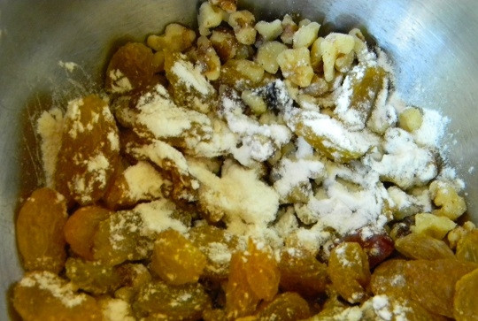 1. Этап. Коврижка медовая с изюмом: 5. Добавьте чайную ложку муки к орехам и изюму и аккуратно перемешайте, после чего выложите добавки в тесто.