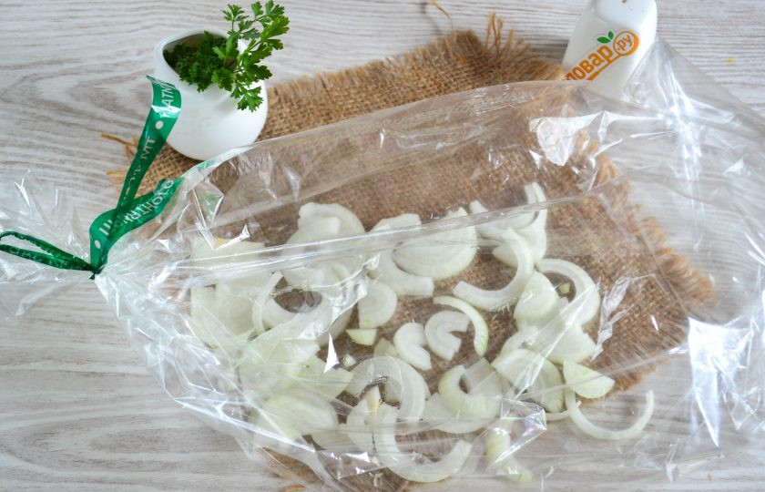 1. Этап. Скумбрия в сметане в духовке: Запекать скумбрию можно как в фольге, так в рукаве. Сегодня я воспользуюсь рукавом для запекания. С одной стороны рукав завяжите, а внутрь положите нарезанный лук.