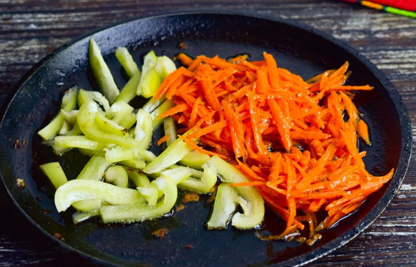 1. Этап. Салат с курицей по-китайски: В сковороде обжарьте морковь и болгарский перец в течение 1-2 минут.