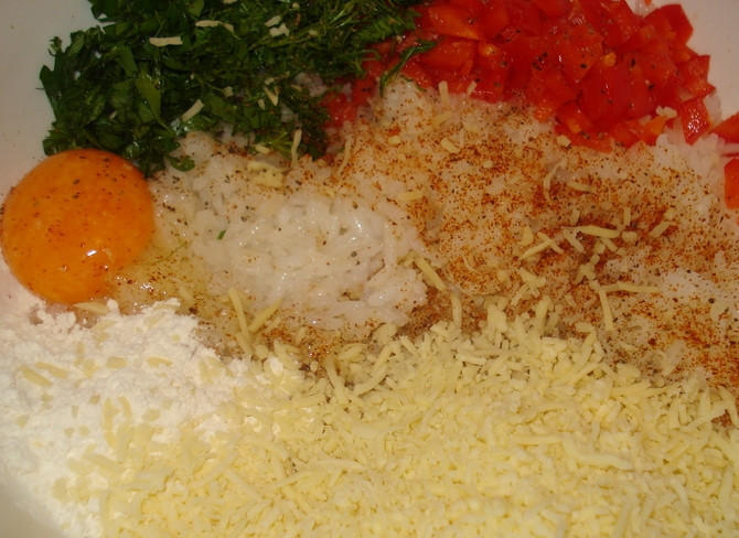 1. Этап. Рисовые котлеты: Выкладываем в глубокую миску предварительно отваренный рис, добавляем натертый на крупной терке сыр, нарезанный мелко красный перец, измельченную зелень, муку и яичный желток. Солим и посыпаем перцем, тщательно все перемешиваем до образования однородной массы.