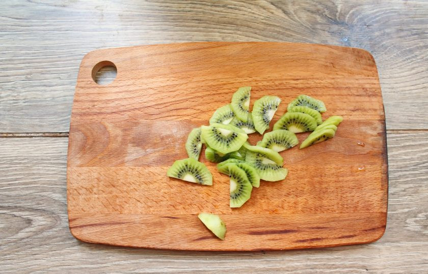 1. Этап. Варенье из клубники с киви: Киви вымойте, почистите от шкурки и порежьте на дольки.