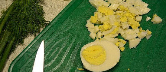 1. Этап. Кальмары с сыром и яйцом: 2. Яйца предварительно отварить вкрутую и остудить. Очистить их и нарезать небольшими кубиками. Чтобы кальмары с сыром и яйцом в домашних условиях были еще более мягкими внутри, яйца можно натереть на терке.