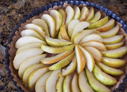 1. Этап. Грушевый пирог без глютена: 4. Параллельно очистите от сердцевины груши, нарежьте их тонкими ломтиками. Можно при желании сбрызнуть их небольшим количеством сока лимона. Выложите фрукты на корж.