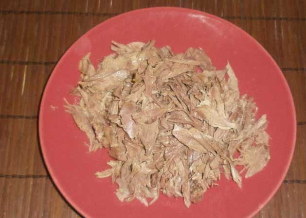 1. Этап. Холодец из утки: Измельчите птицу. Тем временем в бульон добавьте желатин (пачку) и размешайте, чтобы комочков не было.