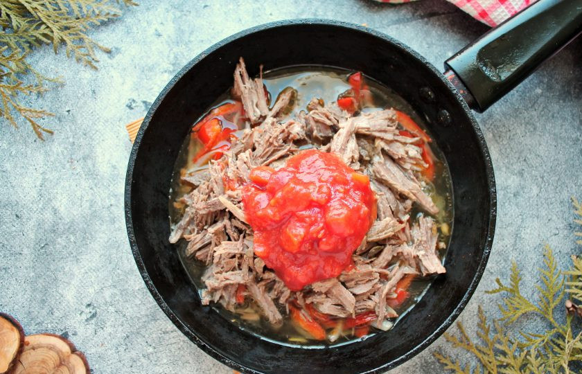 1. Этап. Ропа вьеха: Добавьте в сковороду помидоры в собственном соку и влейте бульон. Убавьте огонь до среднего и тушите все еще 5 минут.