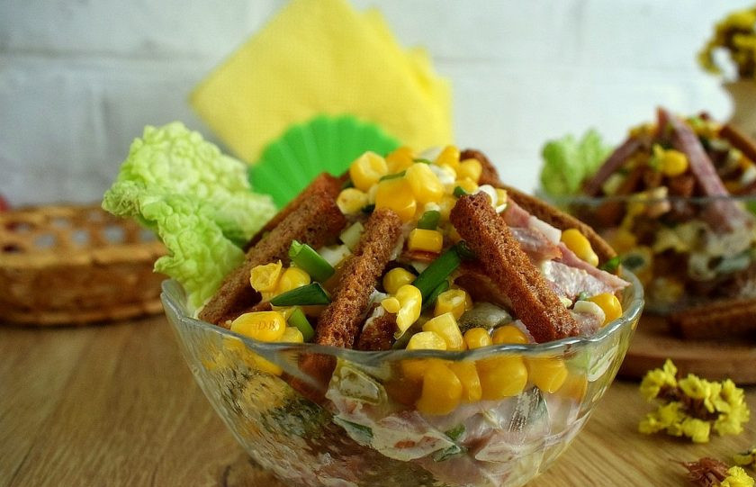 1. Этап. Салат Иришка с сухариками: Зеленый лук измельчите. Смешайте все ингредиенты с майонезом, дайте немного пропитаться. Выложите часть сухариков и кукурузы для украшения.