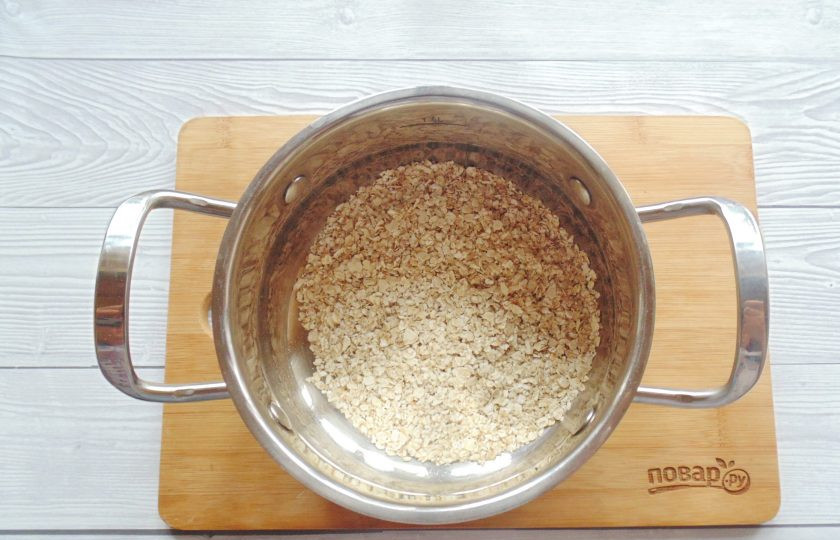 1. Этап. Жидкая овсянка на воде: Овсяные хлопья насыпьте в кастрюлю с толстым дном.