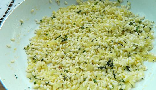 1. Этап. Ризотто с креветками и сливками: Удаляем чеснок и засыпаем рис, перемешиваем и жарим несколько минут.