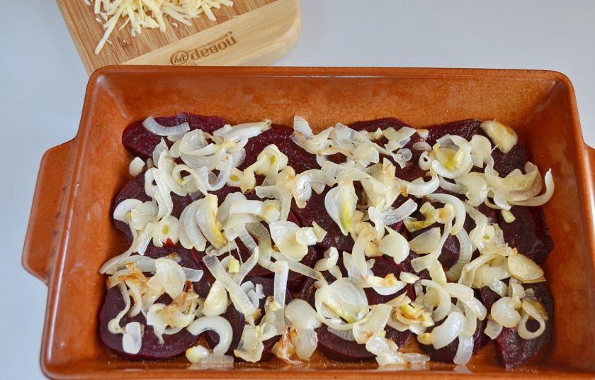 1. Этап. Свекла под сырной корочкой с майонезом: 6. Посолите, поперчите. Распределите сверху чесночные слайсы и жареный лук.