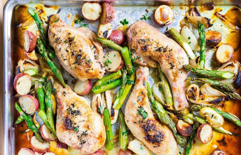 1. Этап. Картошка с курицей в духовке: Добавьте на противень ароматные травы и отправьте все в духовку минут на 40, время от времени перемешивая овощи. Курицу смажьте маслом и посолите по вкусу, отправьте к овощам еще на 30 минут. Добавьте спаржу и готовьте еще 10 минут.