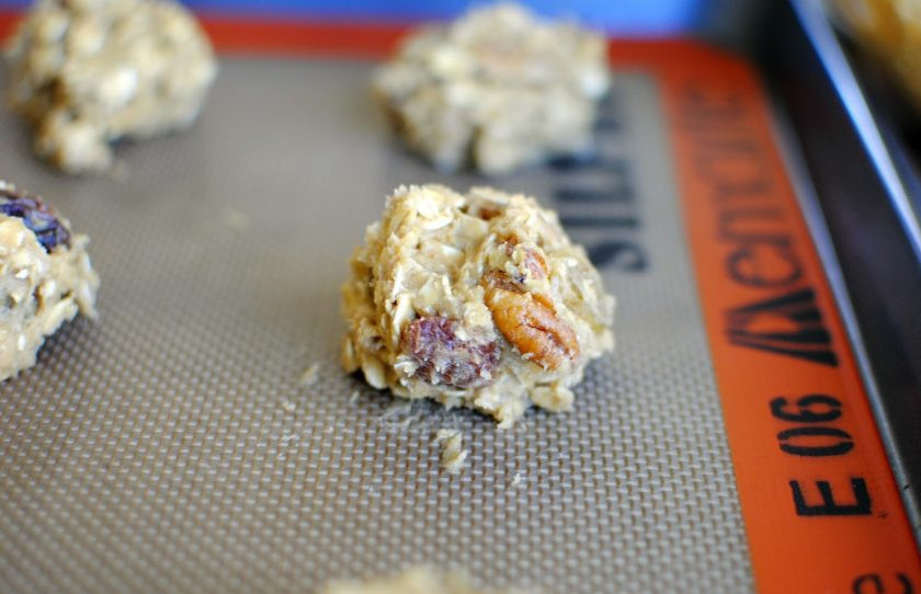 1. Этап. Простое овсяное печенье: Добавьте в тесто отжатый изюм и орешки по вкусу. Духовку разогрейте до 180 градусов. Сформируйте печеньки разложите на противне.