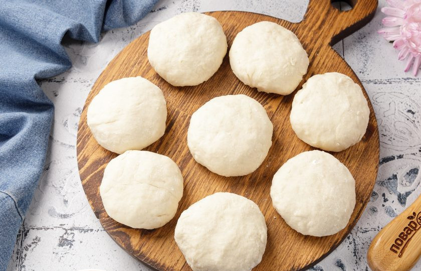 1. Этап. Сырники дрожжевые: Отщипывая от теста кусочки, сформируйте сырники. Если тесто сильно липнет к рукам, обваляйте кусочки в муке.