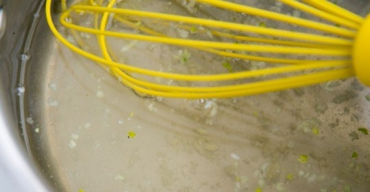 1. Этап. Капустный салат с клюквой: Влейте уксус, растительное масло, выдавите чеснок и влейте воды. Всё перемешайте венчиком.