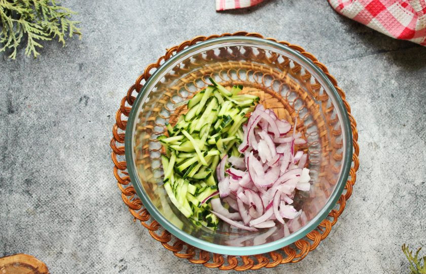 1. Этап. Салат с сыром, огурцом и тунцом: Свежие огурцы порежьте соломкой, красный лук полукольцами. Выложите овощи в салатник.