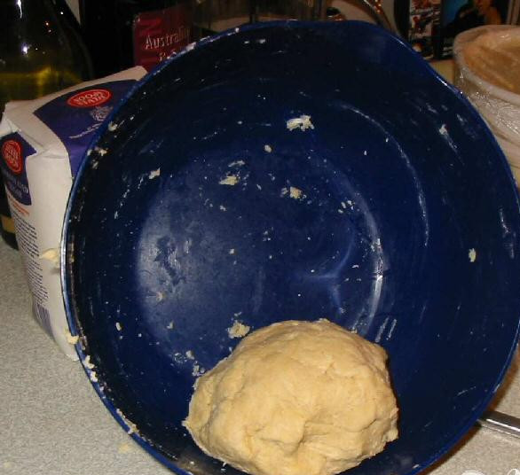 1. Этап. Пирог с курицей и беконом: 3. Смешать маргарин и растительное масло в миске и всыпать муку. Мешать до образования мелких крошек. Добавить 3 ст.л. воды к тесту и перемешать ножом. Замесить тесто руками и скатать в шарик. Завернуть шарик из теста в пищевую пленку и положить в холодильник на полчаса.