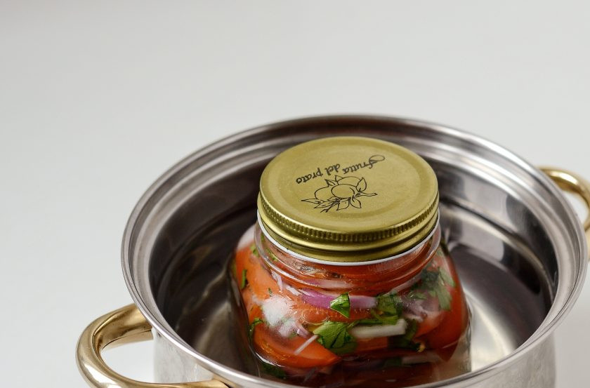 1. Этап. Салат из красных помидоров на зиму: Поставьте банку с рассолом в кастрюлю с водой. Прикройте сверху крышкой и доведите до кипения. Варите на малом огне, пока томаты не пустят сок. Периодически опускайте в банку тонкий нож и выпускайте воздух.