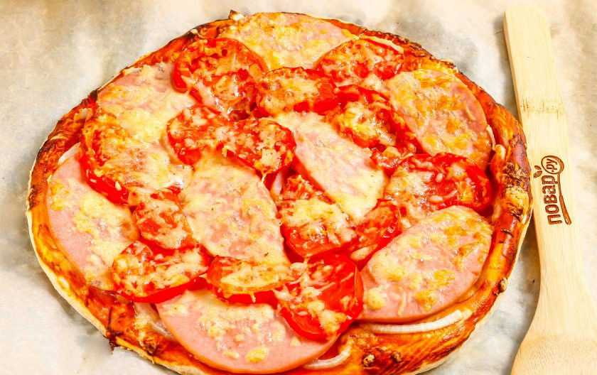 1. Этап. Пицца с колбасой из слоеного теста: Готовую выпечку аккуратно извлеките из духовки и дайте ей слегка остыть.