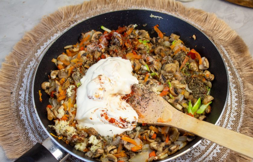 1. Этап. Лазанья из кабачков с грибами: К начинке добавьте сметану и влейте 50-100 мл. воды, доведите соус до кипения и снимите с плиты.