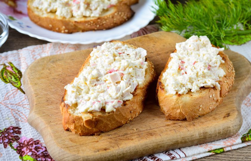 1. Этап. Гренки с крабовыми палочками: Намажьте остывшие кусочки батона крабовой начинкой.