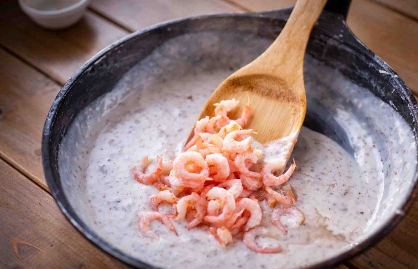 1. Этап. Ньокки с креветками: В сковороду к обжаренной муке залейте струйкой молоко и при этом постоянно мешайте все венчиком, избавляясь от комочков. Эту массу доведите до кипения — соус заметно загустевает. Убавьте огонь до минимального уровня, затем добавьте соль и мускатный орех, перемешайте. Выложите в соус креветки, перемешайте и прогрейте всё 3 минуты, после чего снимите сковороду с готовым соусом с плиты.