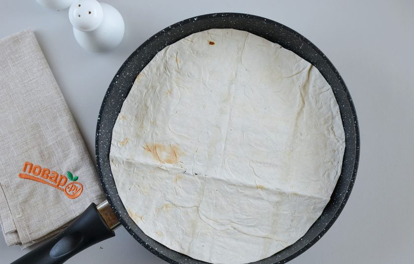 1. Этап. Завтрак с лавашом: Накройте вторым лавашом, прижмите немного руками. Накройте крышкой и готовьте на малом огне 5 минут.