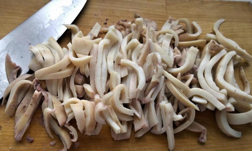 1. Этап. Салат с кальмарами и солеными огурцами: Кальмаров очистите и промойте. Опустите их на 2 минуты в подсоленный кипяток. Потом сразу достаньте, остудите и нарежьте соломкой.