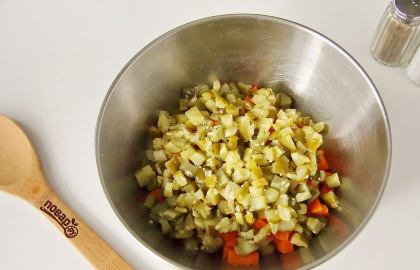 1. Этап. Салат Оливье на год Крысы: Добавьте нарезанные кубиками огурцы, предварительно их слегка отжав от лишней влаги.