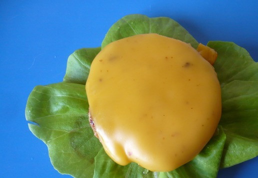 1. Этап. Двойной чизбургер Чили с жареным луком: Подавайте по 2 котлеты на булочке с кетчупом, горчицей, солёными огурцами и маринованным перцем халопеньо. Для приготовления чизбургера берем две булочки, аккуратно разрезаем на две части, смазываем кетчупом и горчицей, сверху уложите листья салата, на салат положите теплую котлету с расплавленным сыром.