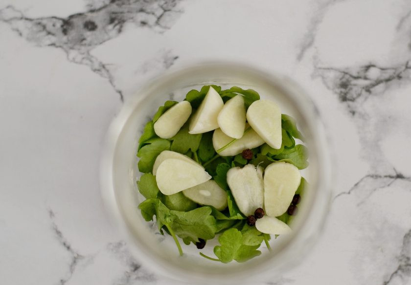 1. Этап. Зеленый болгарский перец на зиму: Пока перцы варятся, подготовьте стерилизованные баночки. На дно положите петрушку, нарезанный пластинами чеснок и перец горшком.