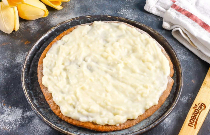 1. Этап. Шоколадный медовик: Выложите первый корж на тарелку, на него выложите часть крема и распределите. Таким образом обмажьте кремом почти все коржи, оставляя 2 из них на крошку.