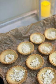 1. Этап. Тарталетки по-новому: На противень, застеленный пергаментом, разместить тарталетки. На дно тарталеток выложить натертый на мелкой терке сырочек