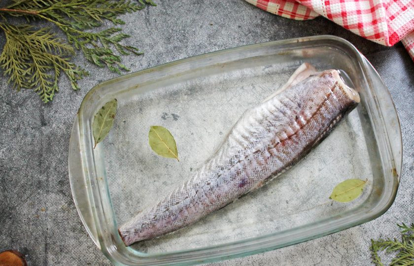 1. Этап. Минтай горячего копчения: Минтай почистите от чешуи, внутренностей и черной пленки с брюшка. Срежьте хвост и все плавники. Если не любите сильно соленую рыбу, срежьте тонкую часть брюшка. В холодной, кипяченной воде растворите соль и залейте подготовленный минтай. Добавьте лавровые листья, черный перец и оставьте в холодильнике на 1.5 часа, после этого рыбу переверните. Дайте ей постоять еще 1.5 часа, после чего достаньте, обсушите и дайте полежать на кухонном столе на бумажной салфетке 2-3 часа, чтобы обсох.